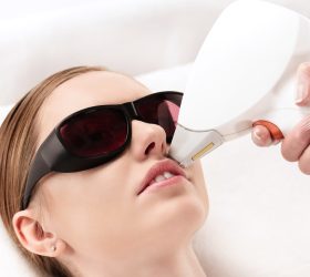 young woman receiving laser hair removal epilation on face. laser skin care concept